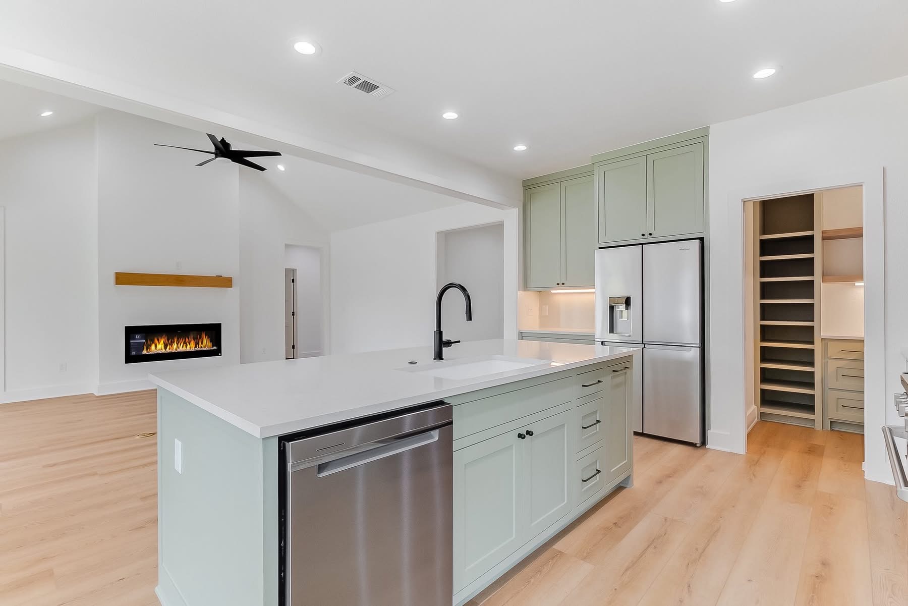 Sage kitchen with island and fireplace